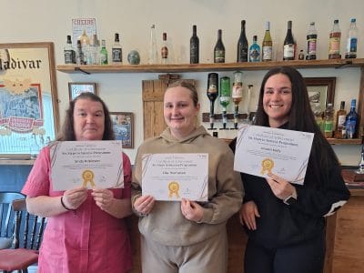Staff celebrating achievements with certificates in a common area
