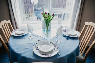 A dining table set with dishes and flowers