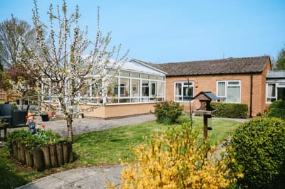 Exterior view of a care home with gardens