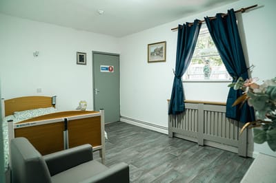 A private resident room with a bed and chair