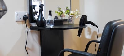 A hair salon setup with a chair and styling tools
