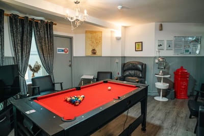 A cozy billiards room with a red pool table