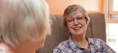 Two smiling residents chatting in a cozy common area