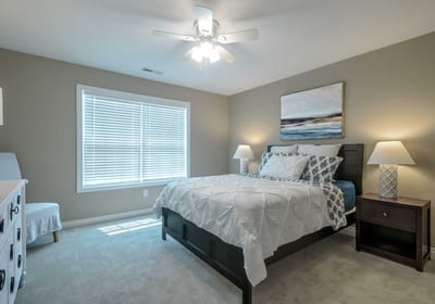 Bright, decorated bedroom with a bed and artwork