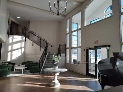 Bright and airy lobby area with seating and a staircase