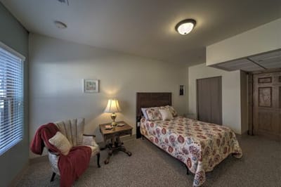Cozy resident room with bed and armchair
