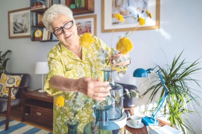 Resident arranging flowers in a cozy indoor space