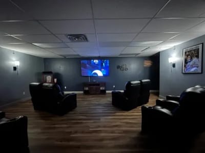 A cozy common area with chairs and a TV