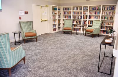 Cozy reading area with comfortable chairs and shelves of books