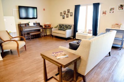 Bright communal area with seating and a piano