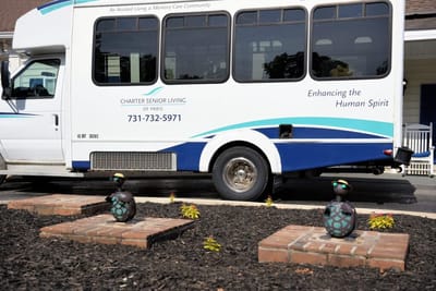 Facility transport van parked with garden decor