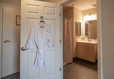 Interior view of a resident's bathroom with a robe