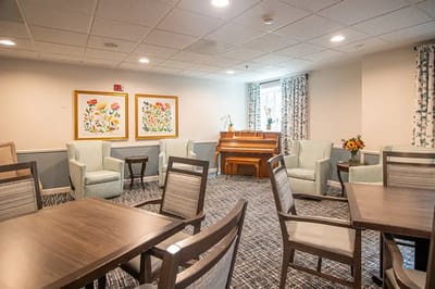 Bright common area with seating and a piano