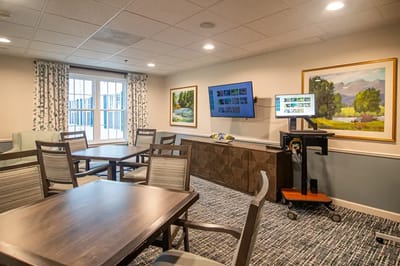 Bright activity room with tables and art on the walls