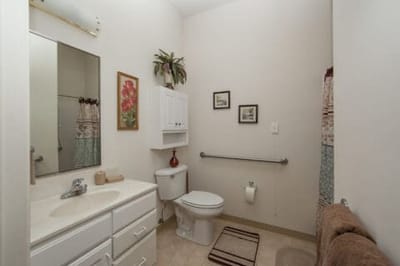 Clean bathroom with light decor and safety features