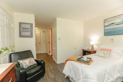 Cozy resident room with a bed and armchair