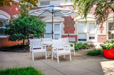 Outdoor seating area with white chairs and umbrella