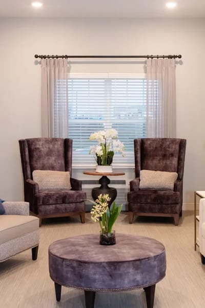 Cozy lounge area with purple chairs and floral decor