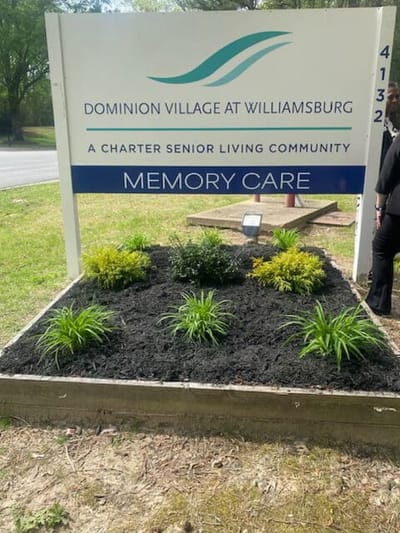 Sign for Dominion Village at Williamsburg with landscaped area
