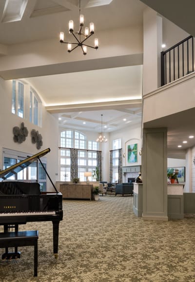Bright interior of a common area with a piano and seating