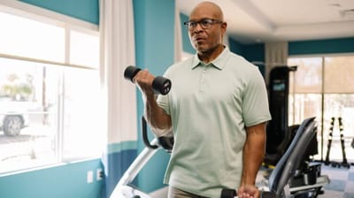 Resident exercising in a fitness area with weights