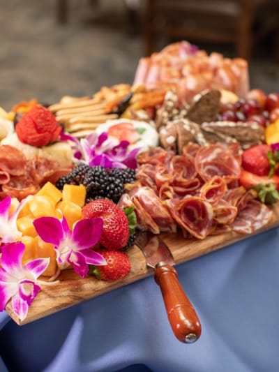 A beautifully arranged charcuterie board with fruits and meats