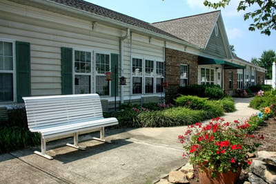Exterior view of a senior living facility with flower beds