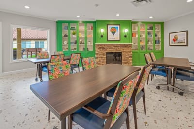 Brightly colored activity room with tables and chairs