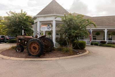 Exterior view of a senior living facility with a tractor