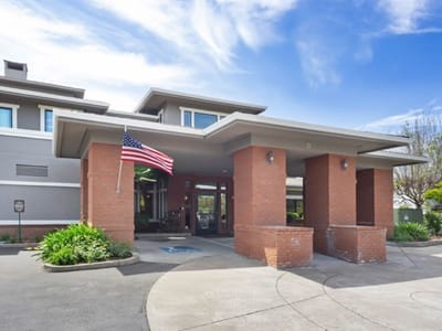 Building entrance with an American flag and landscaping