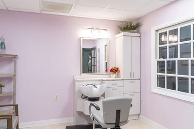 Hair salon area with a salon chair and mirror