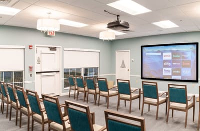Bright common area with seating and a large screen