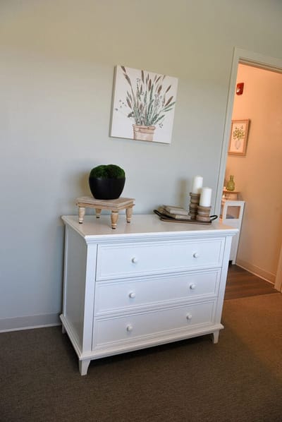 A well-decorated room with a dresser and artwork