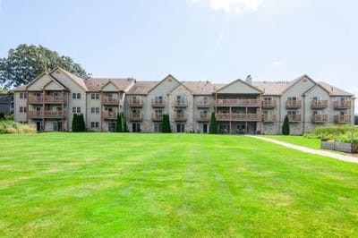Exterior view of Charter Senior Living building and lawn