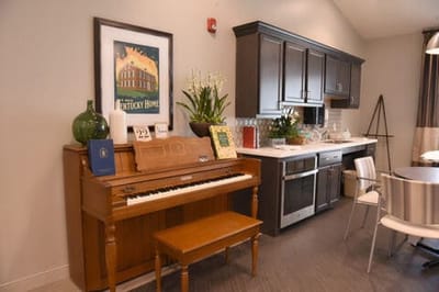 Interior scene with a piano and kitchen area
