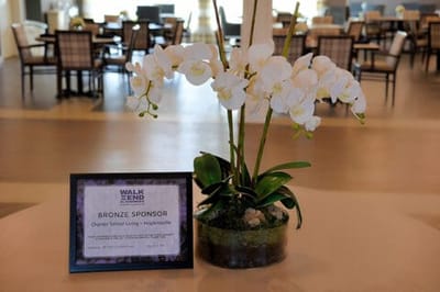 Orchid arrangement with sponsorship sign in a dining area