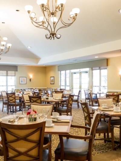 Well-lit dining room with tables set for meals