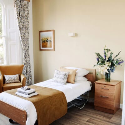 Private resident room with bed and chair