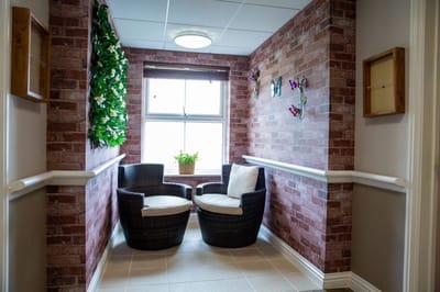 Cozy interior seating area with plants and brick walls