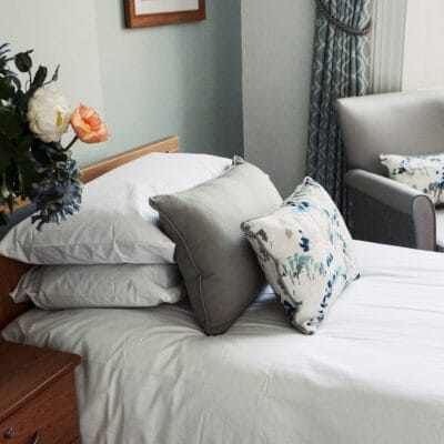 Cozy resident room with decorative pillows on the bed