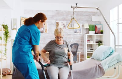 Care staff assisting a resident in a bright room