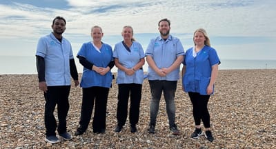 Staff members posing on a beach