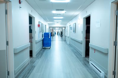 A hallway in a nursing home facility with resident rooms