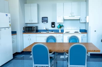 Kitchen area with a table and chairs in a resident unit