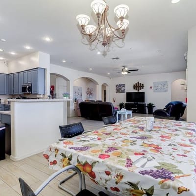 Interior dining area with a decorative tablecloth and chandelier