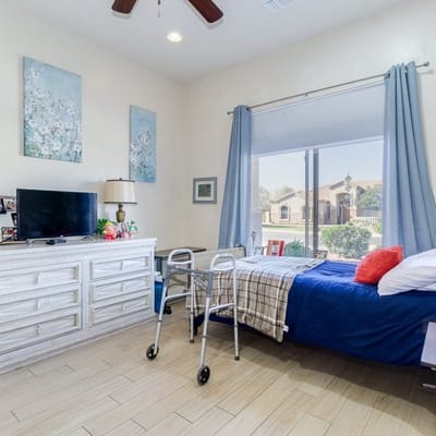 Bright resident room with a bed and wheelchair