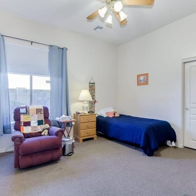 A cozy resident room with a bed and a recliner