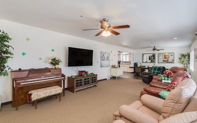 Bright common area with comfortable seating and a piano
