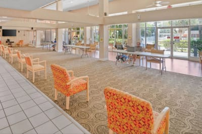 Bright common area with chairs and residents in activity