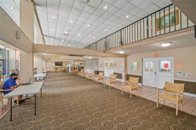 Bright and spacious common area with seating and few residents.